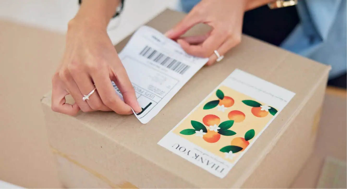 person putting a shipping label on parcel package