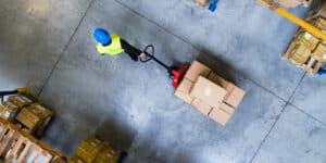 person pulling a pallet jack with boxes