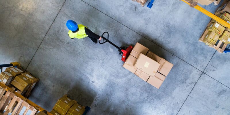 person pulling a pallet jack with boxes