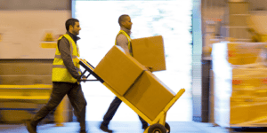 two people moving shipping boxes