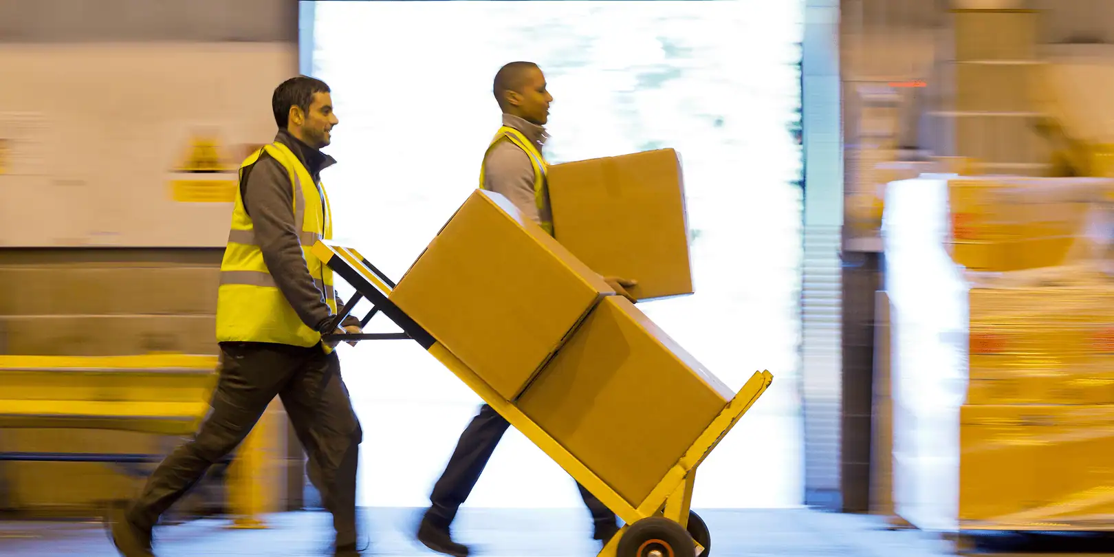 two people moving shipping boxes